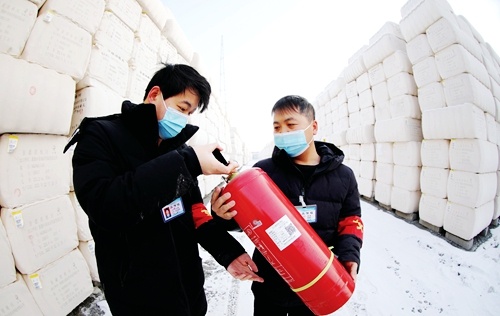 新疆中锦胡杨河仓储物流有限公司安全员在货场内对灭火设备进行检查。