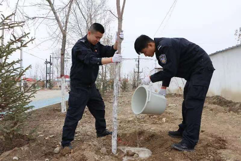 3月12日，驻五师八十九团柯依塔什边境派出所开展植树活动，图为民警为树木浇水。孙京京 提供