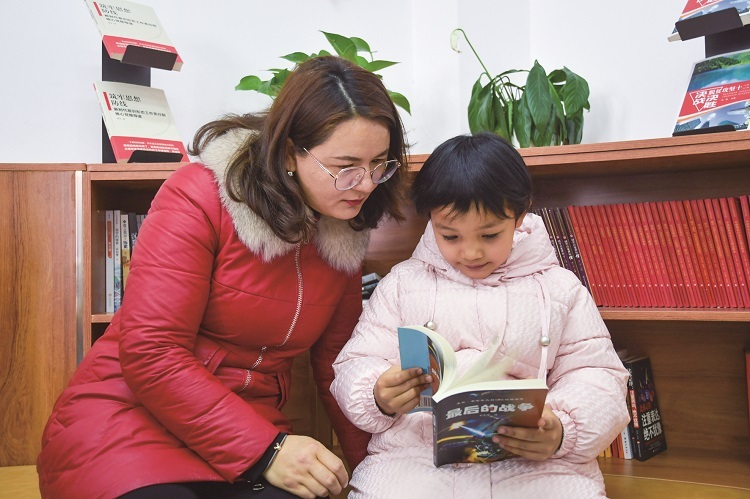 3月22日，新疆兵团第三师五十一团唐驿镇连队居民带着孩子在阅览室阅读书籍。 刘杰