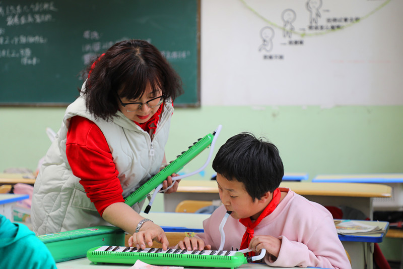 3月29日，学生在老师指导下练习电子琴。李晓丽摄