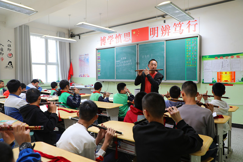 3月29日，老师在课堂上教学生练习笛子吹奏的手法。李晓丽摄