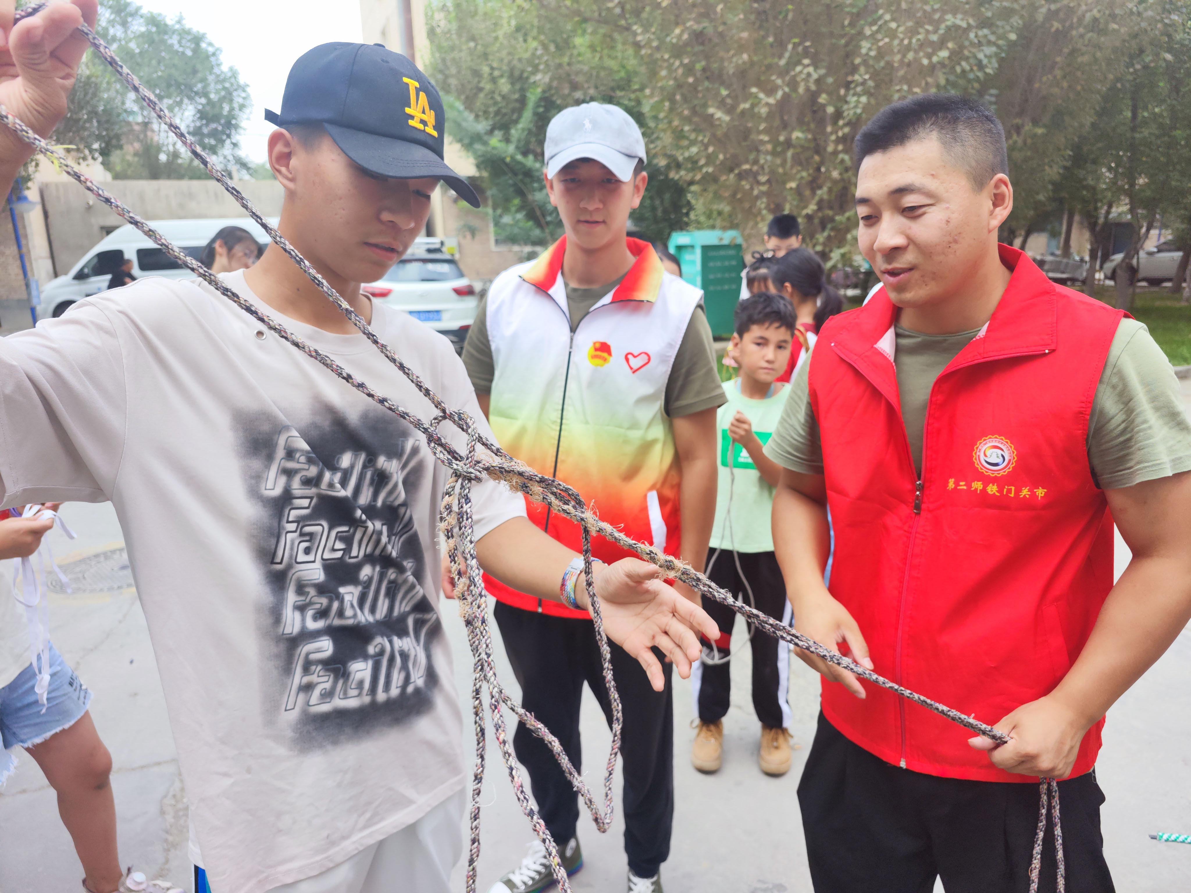 退役军人志愿者手把手地指导学生学习逃生绳结的系法。彭洁 摄