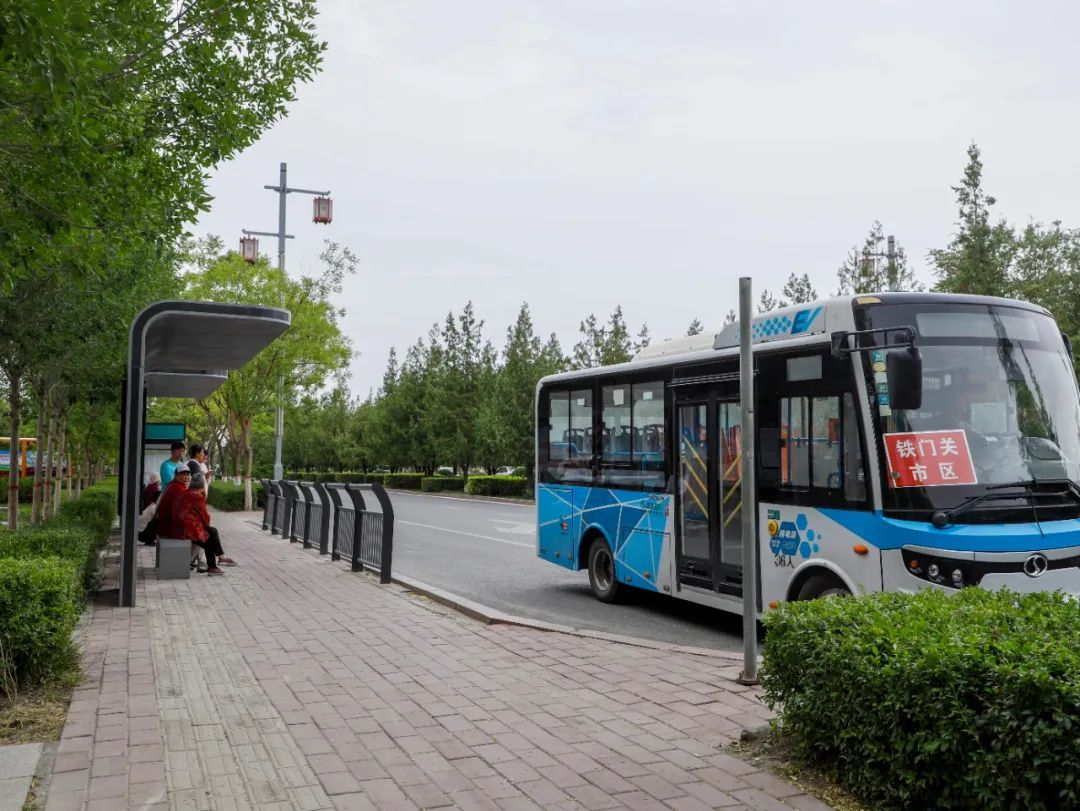 铁门关市市民在公交车站台等车。史俊毫 摄