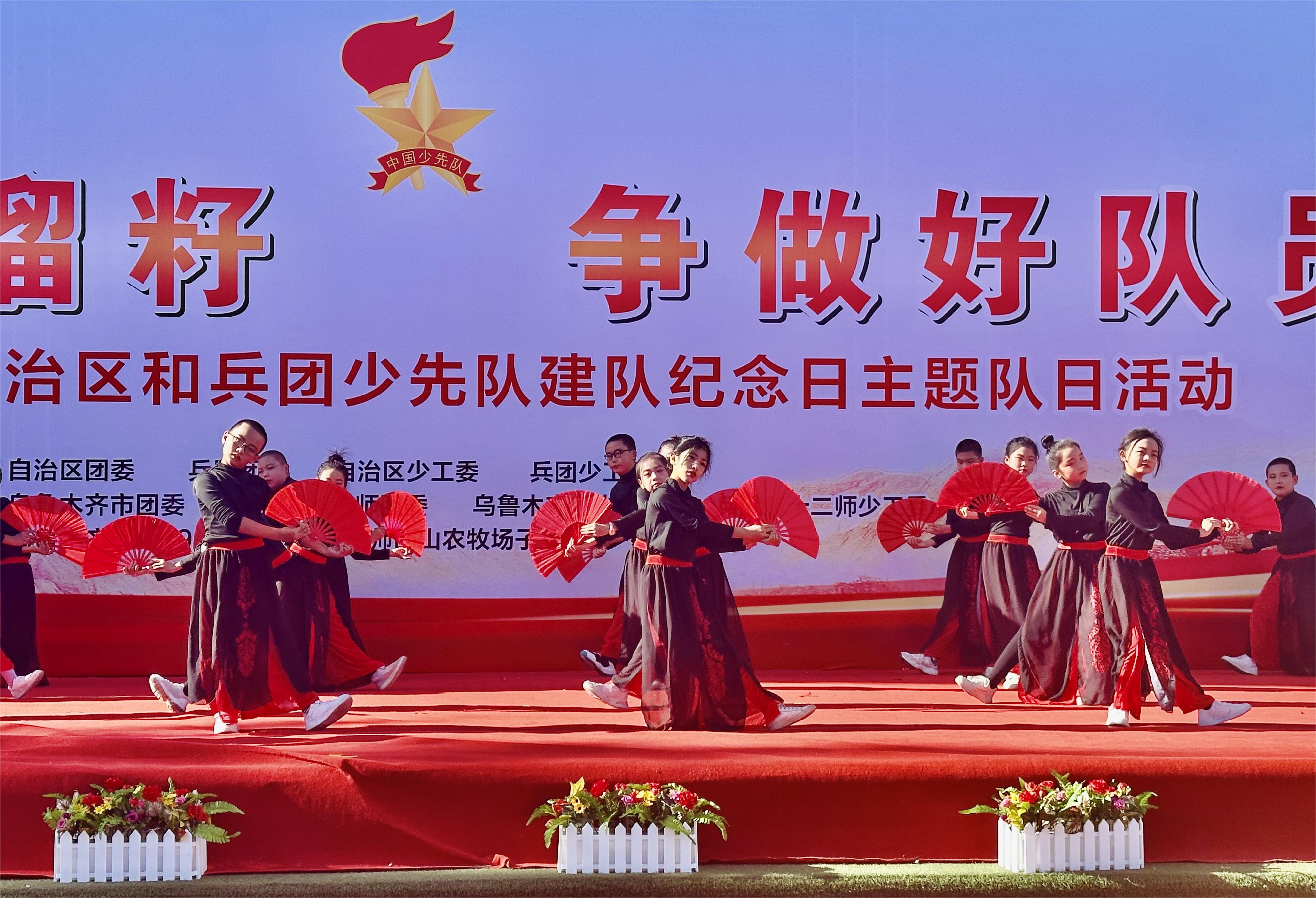 西山农牧场子女学校的少先队员表演中国风扇子舞《雪龙吟》。杨永霞 摄