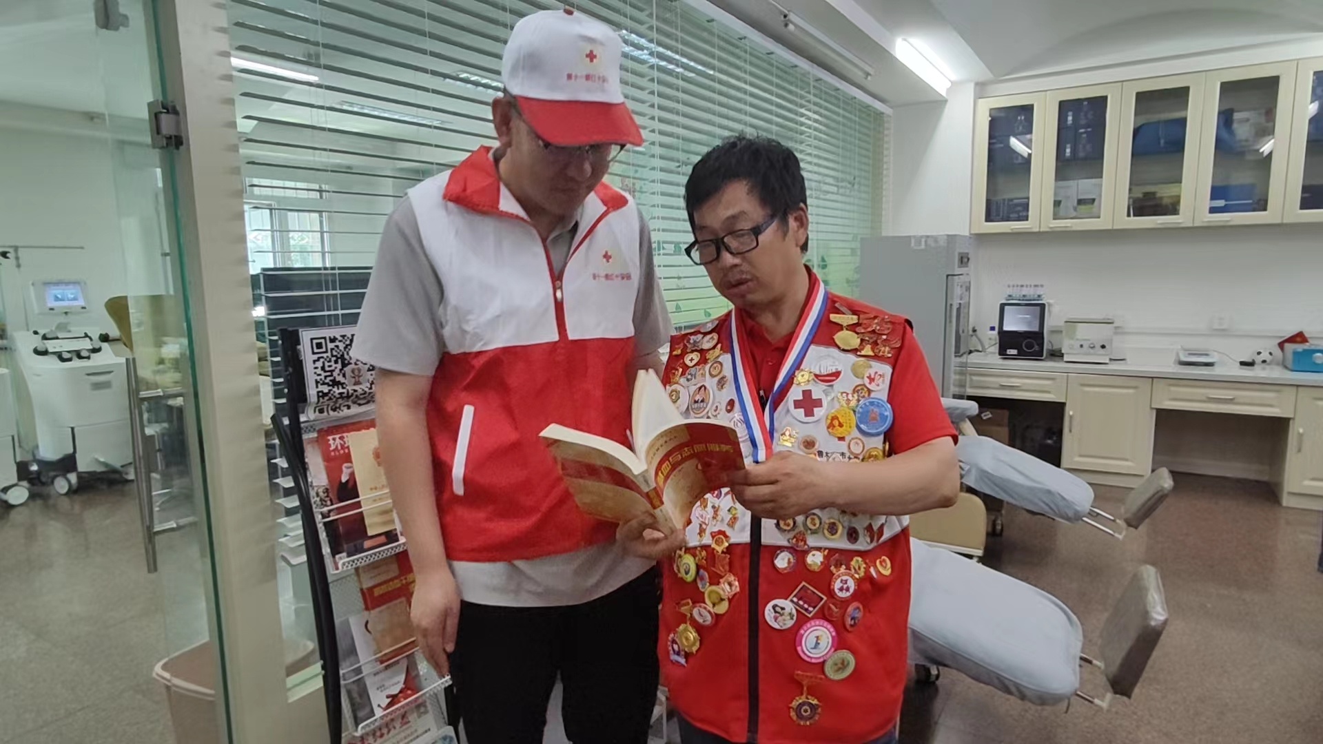 6月11日，王俊周（右）向献血者普及相关献血知识。