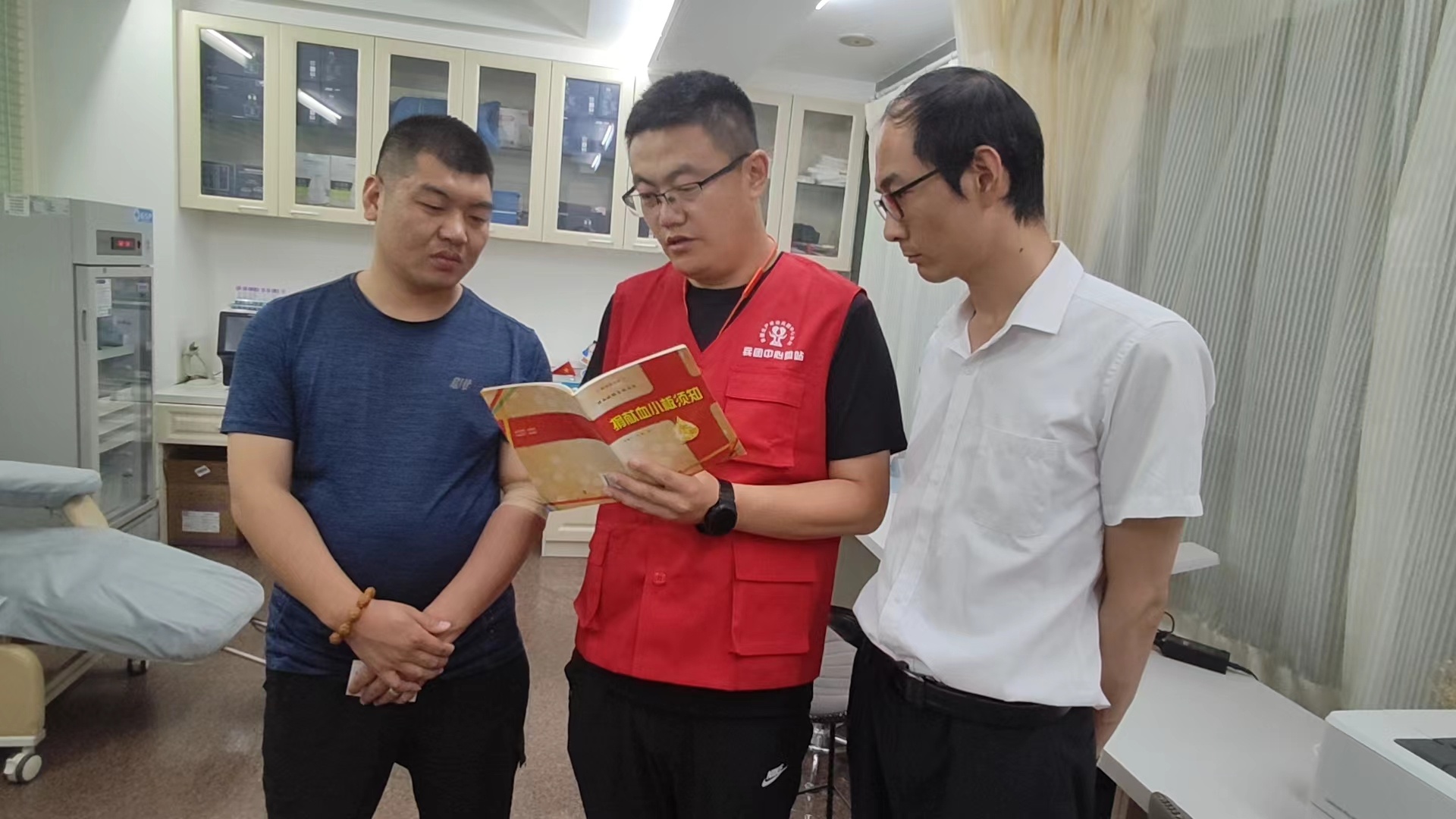 6月11日，石伟（中）在兵团中心血站为大家讲解无偿献血的知识。