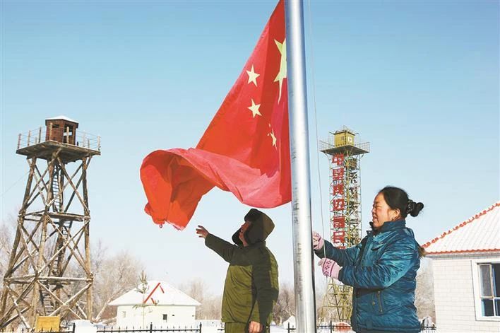 马军武与妻子张正美在哨所升国旗（资料图片）。张文成 摄.jpg