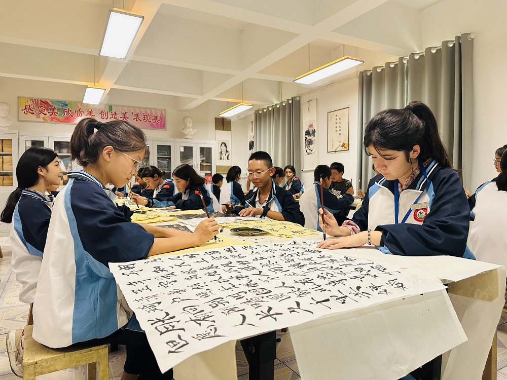 各民族学生一起学习传统书法。李萍 摄.png