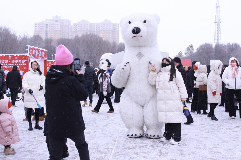 伴随着漫天飞雪，游客在打卡拍照。.jpg
