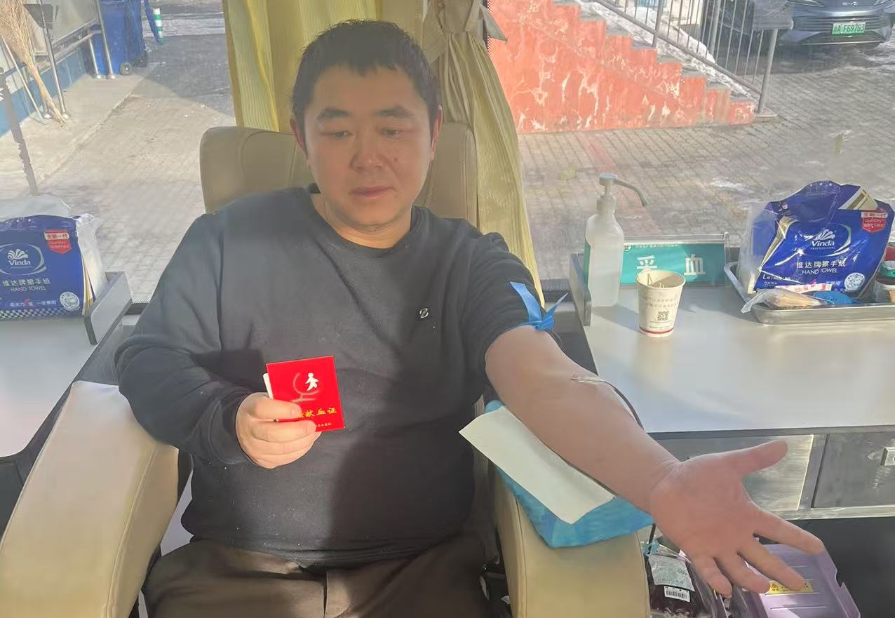 一位先生献血后取得献血证很开心。梁艳摄.jpg
