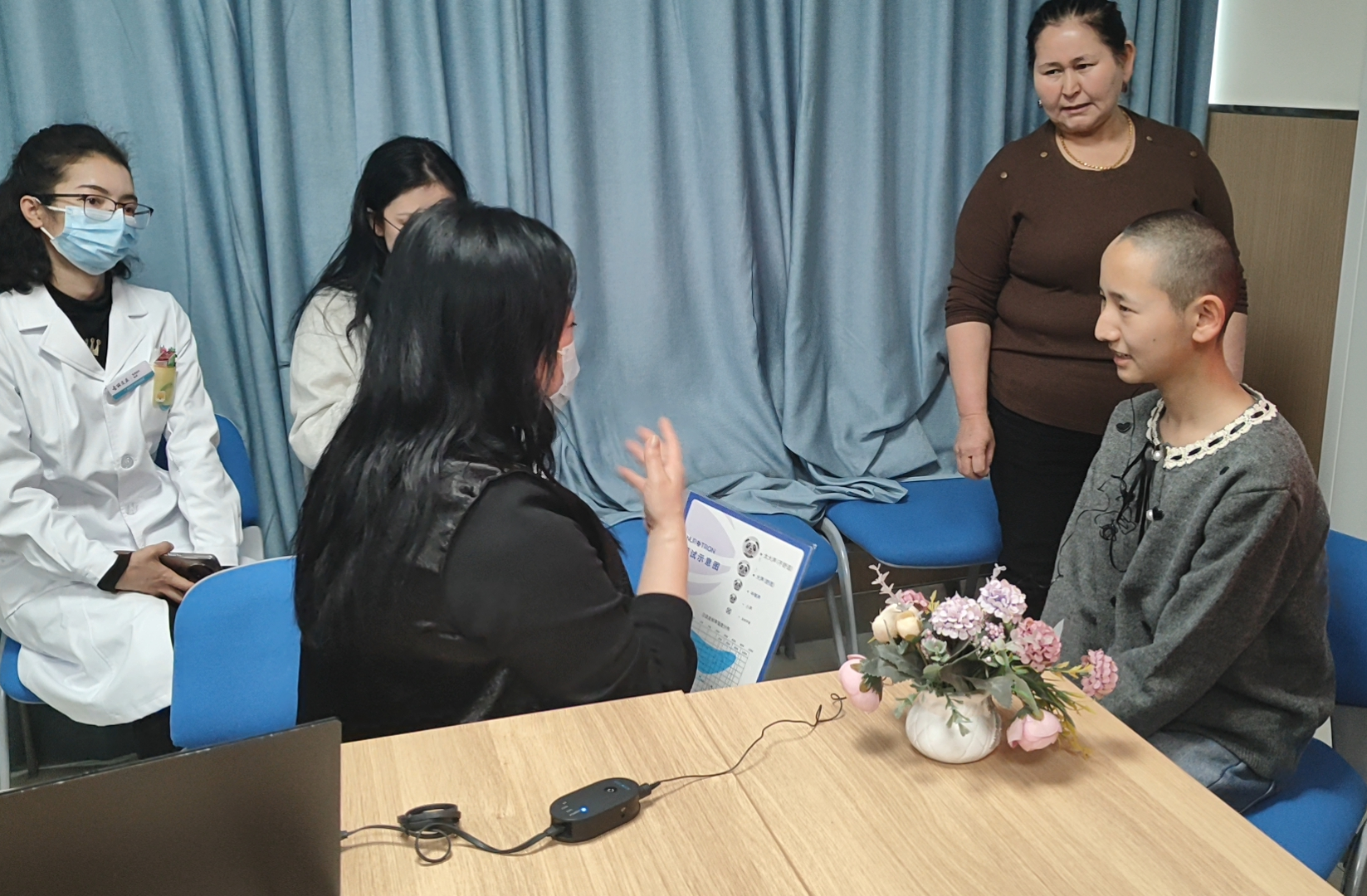 患者佩戴人工耳蜗后，患儿在和调音师交流。梁艳摄.png