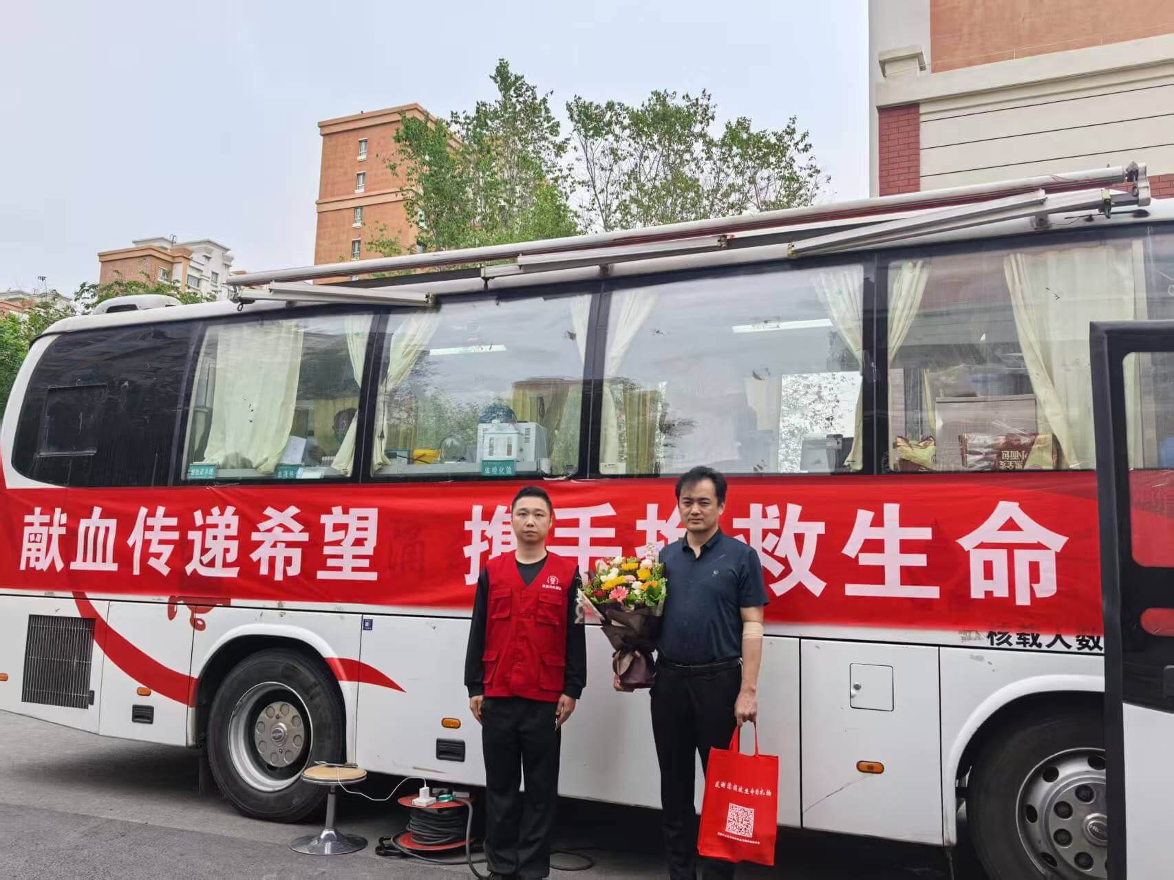 献血者在兵团中心血站献血车前合影。.jpg
