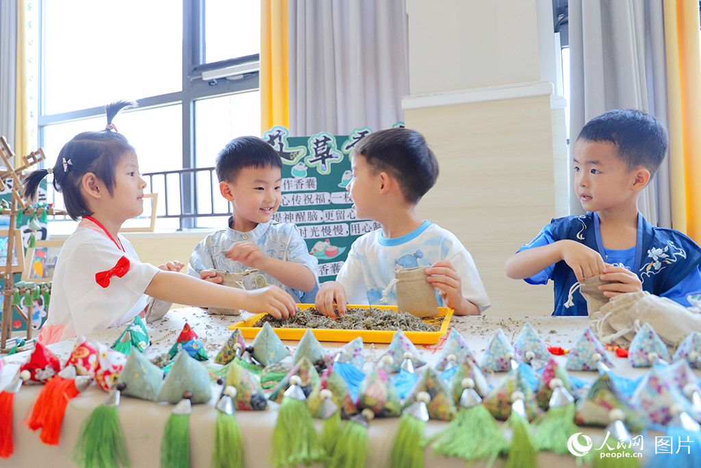 2025年5月30日，山东省济南市历下区百合幼儿园的孩子们巧手缝制艾草香包，喜迎六一端午双节。人民网记者 刘祺摄