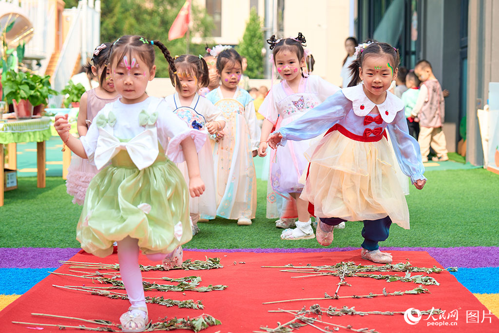 2025年5月30日，山西省太原市，孩子们用脚踩艾叶的方式喜迎端午六一双节。人民网 张超宁摄