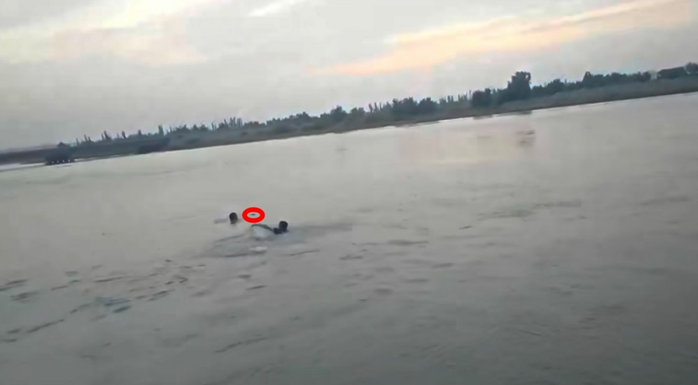 民警辅警正在河中救援同事李宗明，红圈处为淹没在河中的李宗明。.jpg