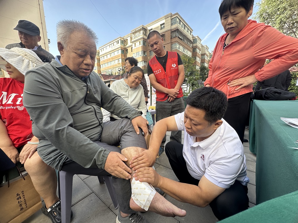 医护团队为当日到场的老人贴膏药缓解疼痛。李萍 摄.jpg