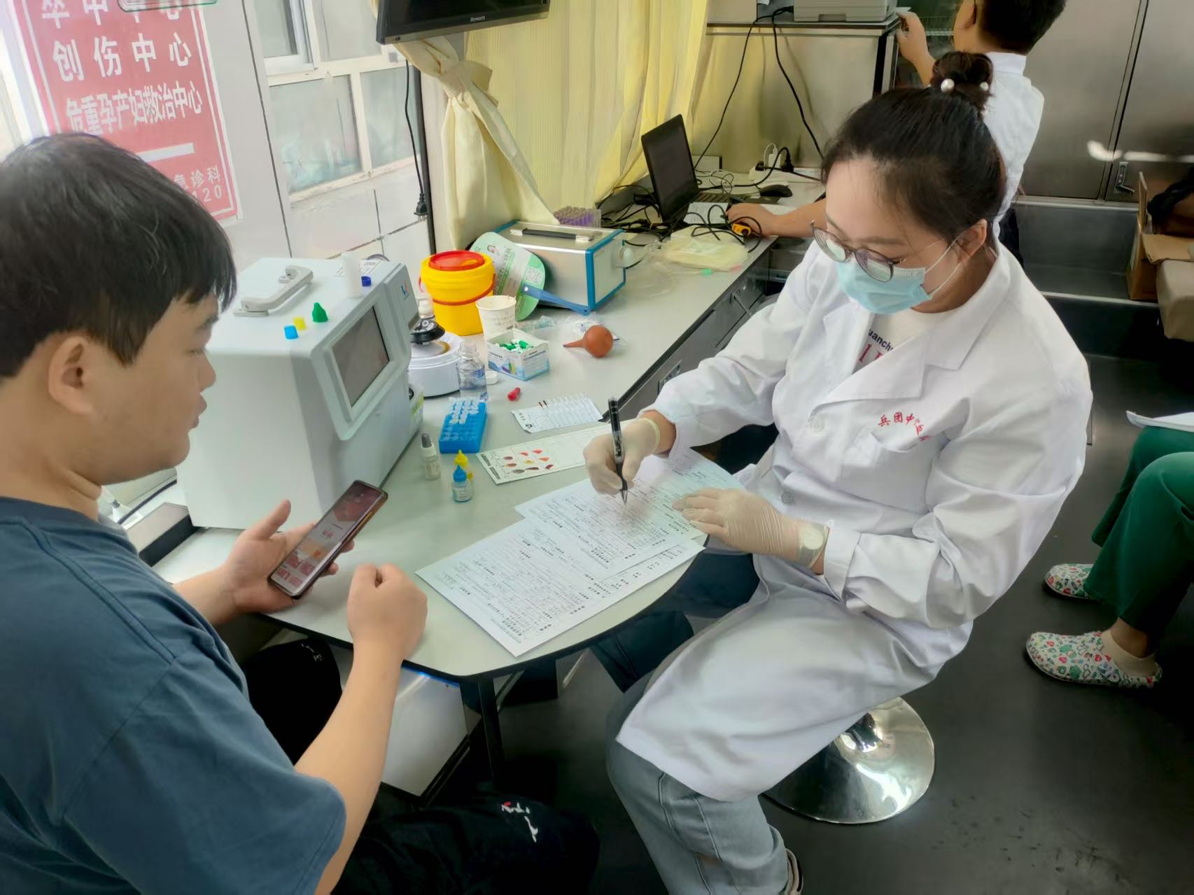 兵团中心血站工作人员为献血者填表格。.jpg