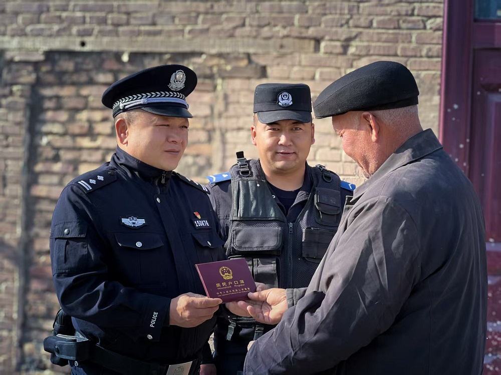 努尔艾力·吐洪(左一)为居民送去办理好的户口本。.jpg 努尔艾力·吐洪(左一)为居民送去办理好的户口本。.jpg