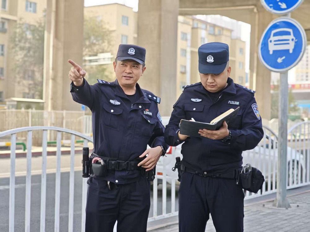 杨波(左)与同事在道路上巡查。.jpg 杨波(左)与同事在道路上巡查。.jpg