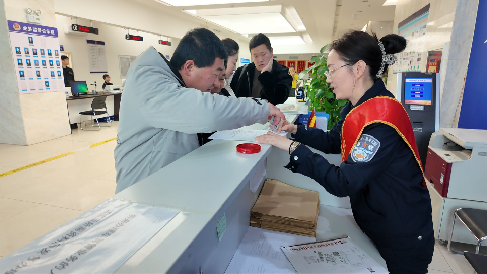 十二师公安局车辆管理所工作人员为前来办理业务的市民整理材料.png