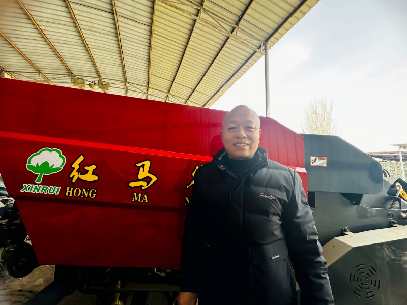 文长建站在”红马农装”残膜回收机前，满是自豪，这是他多年钻研的成果。李萍 摄.jpg