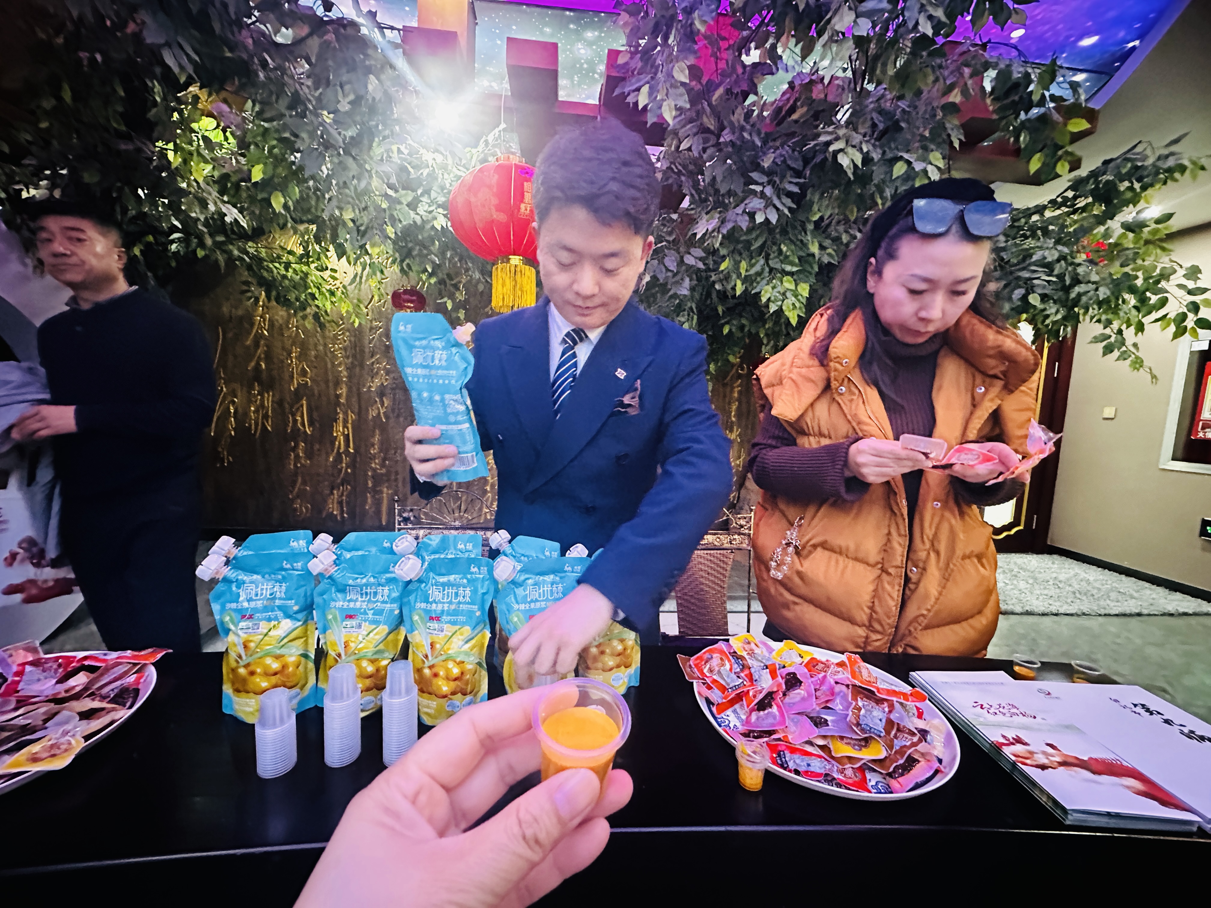 第九师白杨市文化体育广电和旅游局文旅推荐官肖亚文请参观者品尝九师的沙棘全国原浆。李萍 摄.jpg