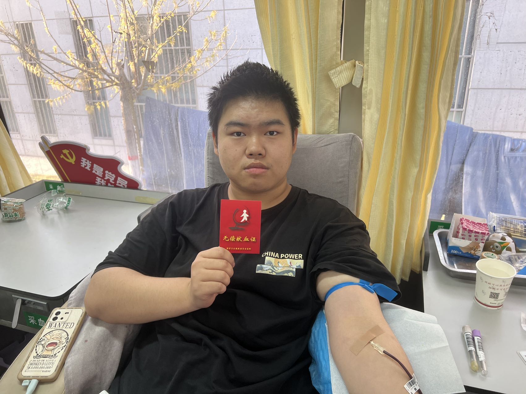 一位男同学献血后展示献血证。梁艳摄.jpg