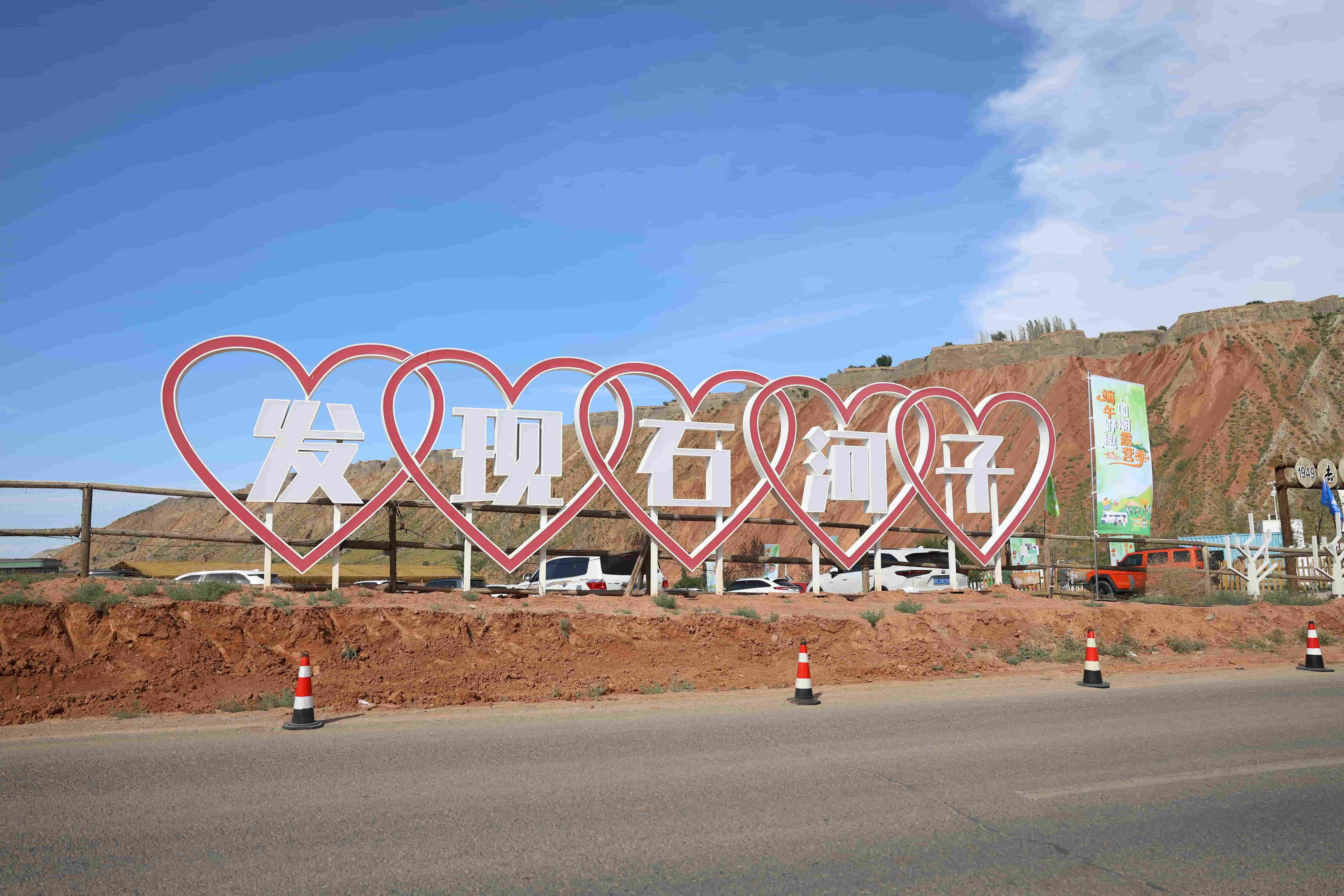 1949・百里丹霞公路营地 “发现石河子” 网红打卡点醒目亮相,丹霞红岩作天然背景,迎接市民游客奔赴端午国潮露营盛会。.jpg
