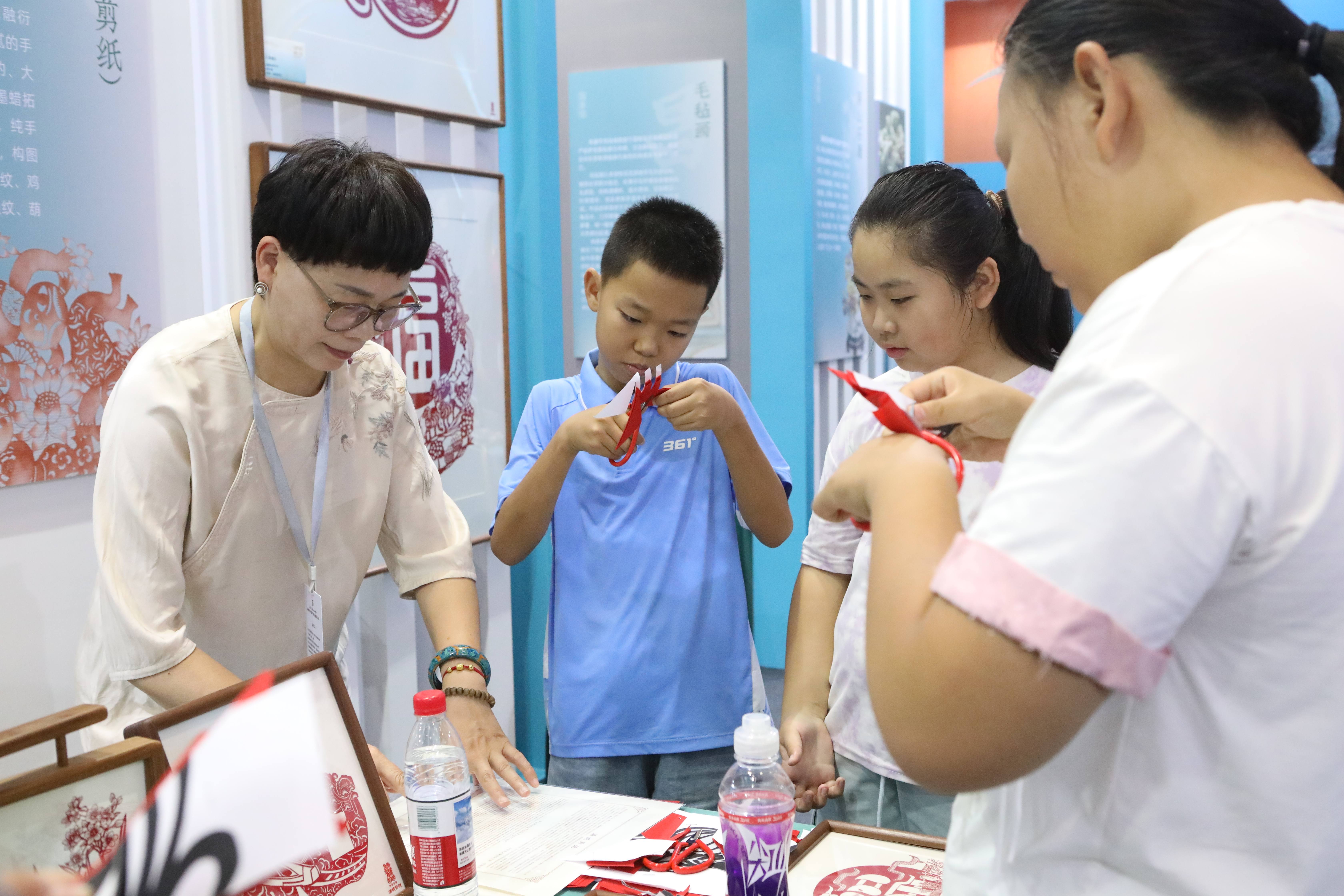 参展观众在现场跟随老师一起体验剪纸。胡杨网记者 李雨浪 摄.jpg