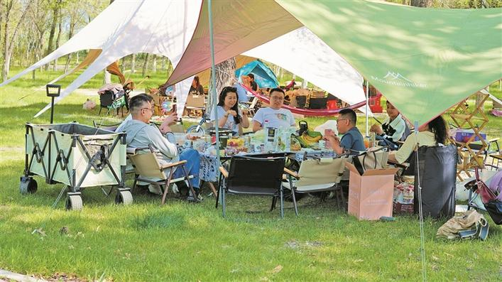 游客在十二师五一农场露营地搭起帐篷，享受闲暇时光（资料图片）。马丽 摄