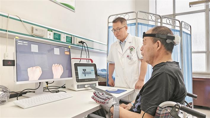 在七师医院康复科，医师指导患者穿戴无创脑机接口设备开展康复训练（摄于8月25日）。赵丰 摄
